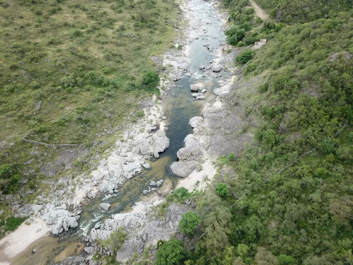 Vista aérea del río encajonado entre rocas y monte serrano.